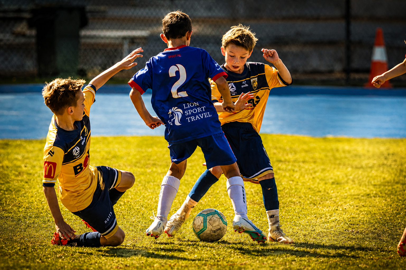 Three players tangled in a tackle for the ball